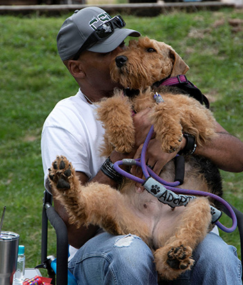 Man hugging a dog on his lap
