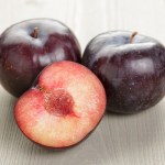 three plums on a table